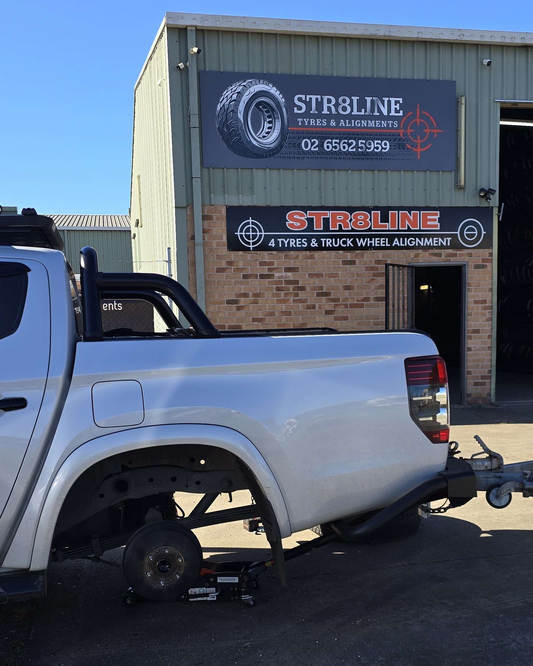 The Str8line shopfront on Queen Street with a ute up on a jack outside