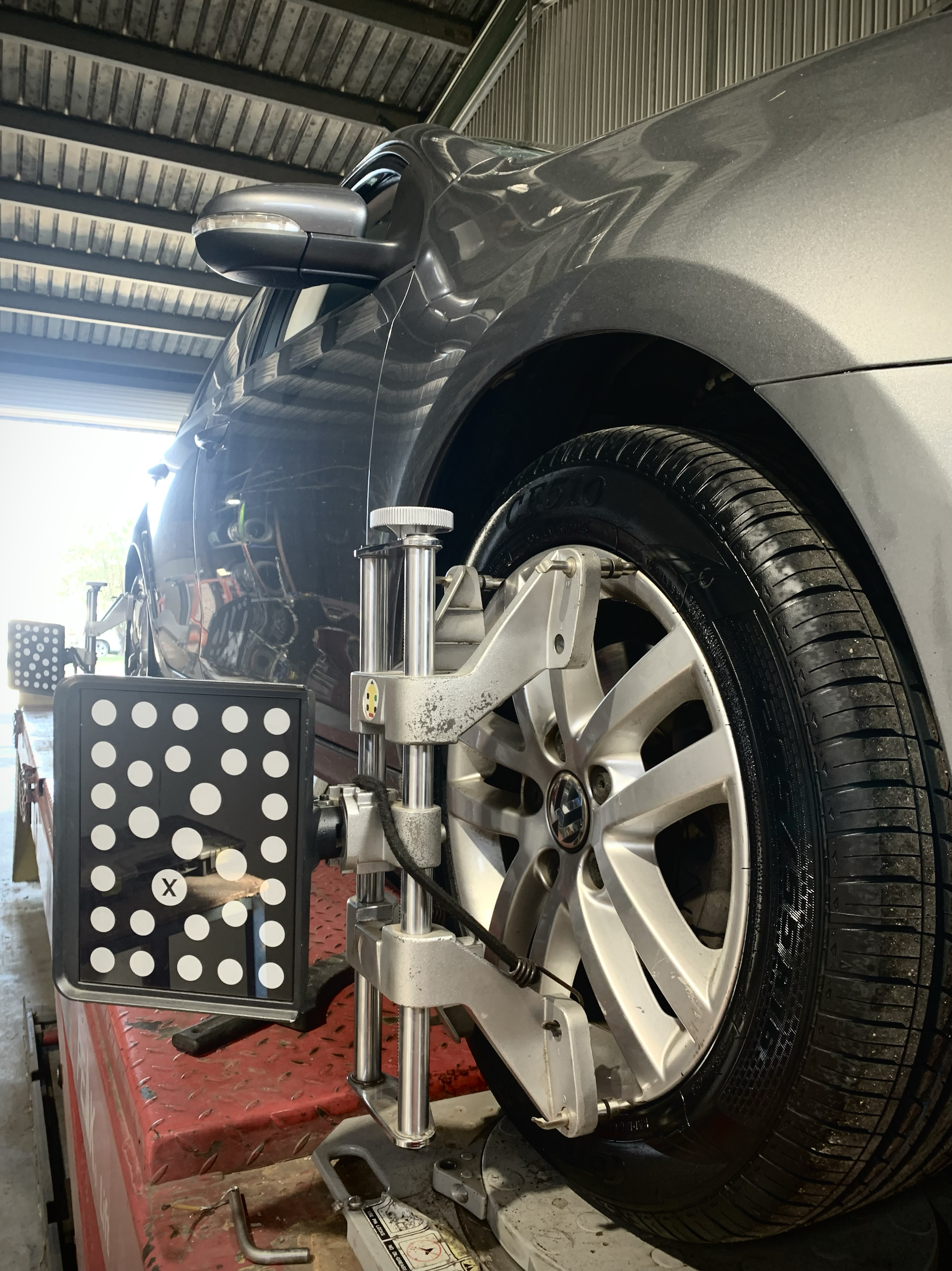 Alignment head and camera target clamped to a front wheel on the rack